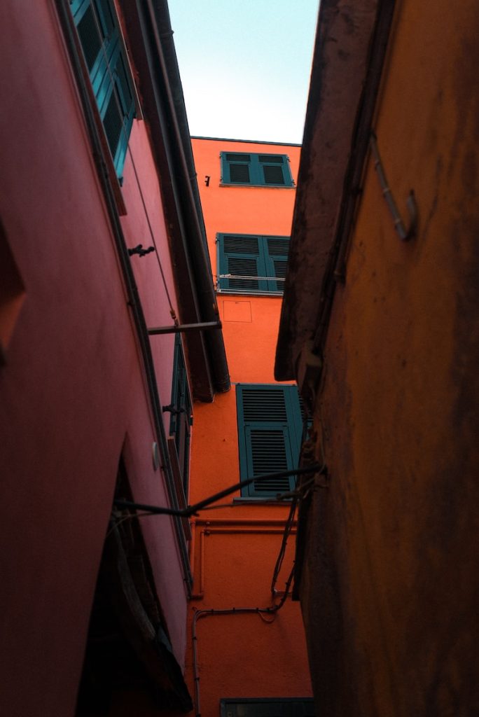 blue window type air conditioner on orange concrete building
